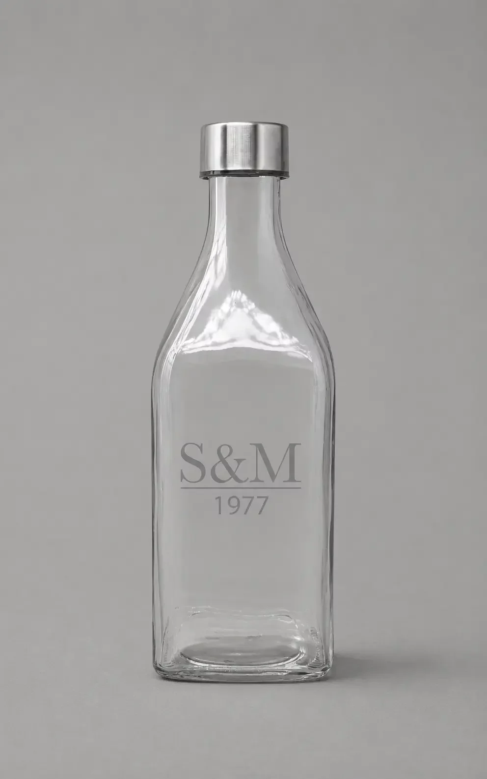 Bouteille en verre carrée avec bouchon argenté DELTA. Bouteille en verre carrée avec bouchon argenté DELTA.